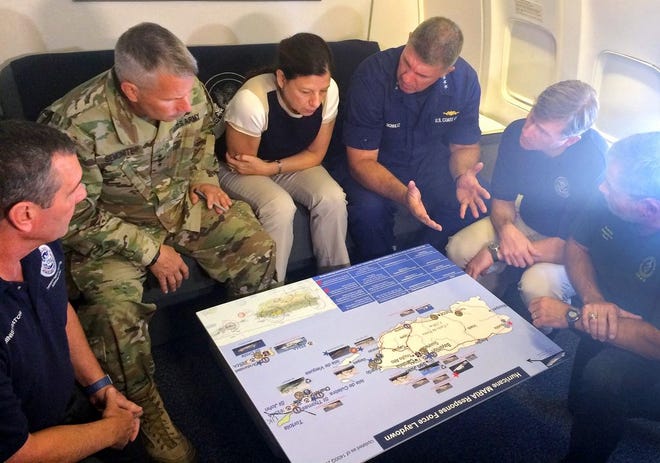 Acting Homeland Secretary Elaine Duke, center, is briefed on the Hurricane Maria response during a flight to Puerto Rico on Friday. President Donald Trump on Thursday cleared the way for more supplies to head to Puerto Rico by waiving restrictions on foreign ships delivering cargo to the island.