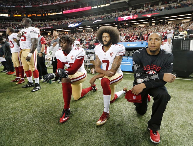 San Francisco 49ers quarterback Colin Kaepernick (7) and outside linebacker Eli Harold (58) kneel during the playing of the national anthem before a 2016 game. [JOHN BAZEMORE/AP FILE PHOTO]