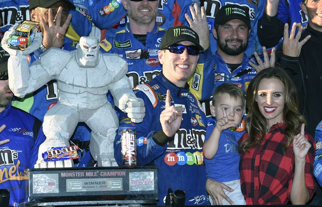 Kyle Busch, third from right, poses with the trophy with his son Brexton, second from right, and wife Samantha, right, after his win Sunday in Dover, Delaware. [Associated Press/Nick Wass]