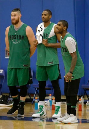 The Celtics' Aron Baynes, from left, Al Horford and Kyrie Irving react from the bench during training camp last week.