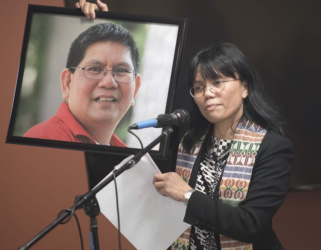 Rev. Sandra Pontoh holds a photo of Terry Rombot, an Indonesian member of the Seacoast community who is among those facing deportation, during an interfaith service held in early September at the McConnell Center in Dover. [John Huff/Fosters.com, file]