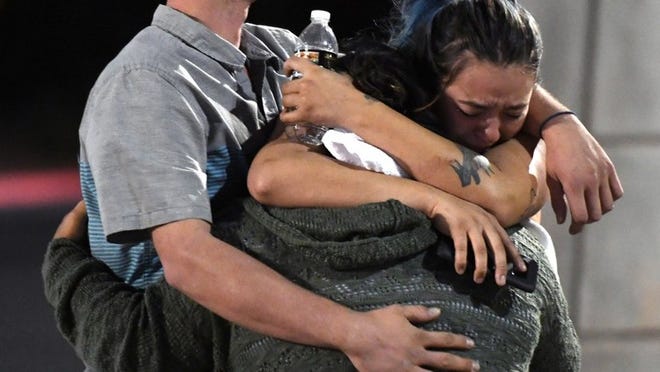 People hug and cry outside the Thomas & Mack Center after a mass shooting at the Route 91 Harvest country music festival early Monday morning in Las Vegas. ETHAN MILLER/GETTY IMAGES