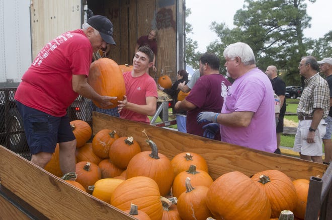 David Elmore (left) takes a pumpkin from Michael Hargroder as other volunteers help unload a truck Monday afternoon at First United Methodist Church in Houma. Starting today, the pumpkin patch will be open 10 a.m. to 6:30 p.m. weekdays and Saturdays, and 1-6:30 p.m. Sundays. Those interested in booking a group field trip can call 868-7793.

[Chris Heller/Staff -- houmatoday/dailycomet]
