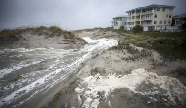 Waves from Tropical Depression Irma wash into the sand dunes that separate the homes from the beach on Sept. 11 on Tybee Island. (AP photo/Stephen B. Morton)