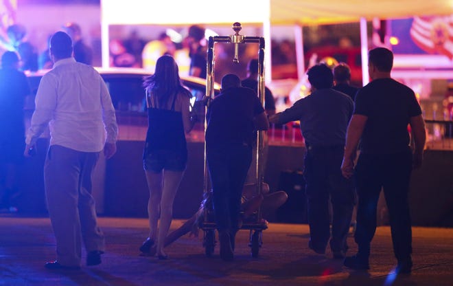 A wounded woman is moved outside the Tropicana on Sunday night during an active shooter situation on the Las Vegas Strip in Las Vegas. Multiple victims were being transported to hospitals after a shooting late Sunday at a music festival on the Las Vegas Strip. [Chase Stevens/Las Vegas Review-Journal via AP]