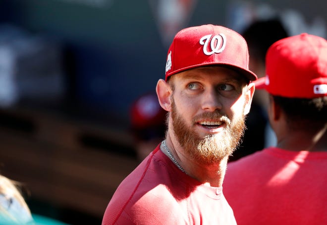 Washington Nationals starting pitcher Stephen Strasburg smiles as he walk into the dugout during practice at Nationals Park, Tuesday, Oct. 3, 2017, in Washington. Game 1 of the National League Division Series against the Chicago Cubs is Friday. (AP Photo/Alex Brandon)
