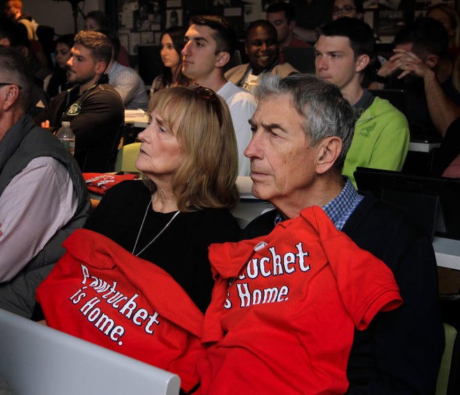 Joanie and John Moser of South Kingstown listen to testimony while draped in T-shirts showing their support for a new Pawsox stadium. [The Providence Journal / Kris Craig]