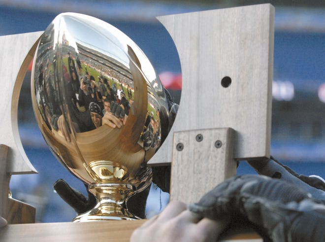 From the 2007 football state championship, members of the Pueblo West High School football team see themselves in the reflection the state championship trophy.