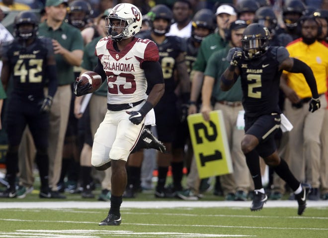 Oklahoma running back Abdul Adams (23) breaks away to score a touchdown against Baylor safety Taion Sells (2) during the first half of an NCAA college football game in Waco, Texas, on Saturday. It's not quite the tandem of Samaje Perine and Joe Mixon, but Oklahoma's running back combination of Abdul Adams and Trey Sermon is getting the job done. [AP Photo/LM Otero, File]