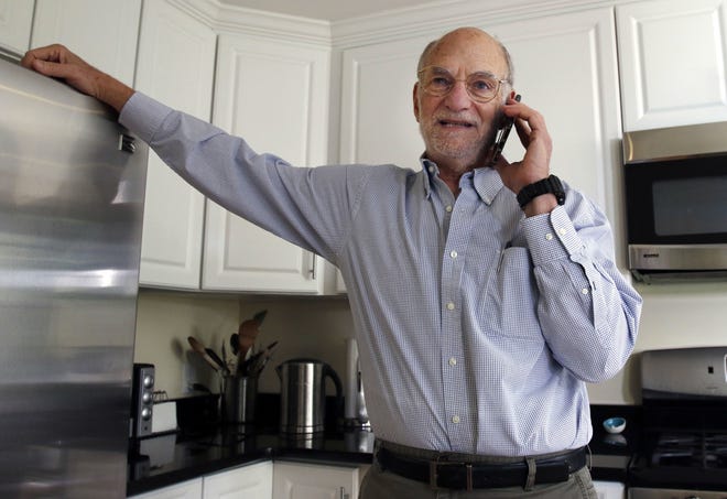 Michael Rosbash takes a phone call at his home, Monday, Oct. 2, 2017, in Newton, Mass. Rosbach is one of the Americans awarded this year's Nobel Prize in physiology or medicine for discovering the molecular mechanisms that control humans' circadian rhythm. [AP Photo/Bill Sikes]