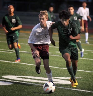 Salina Central's Luke Beatty, left, and Salina South's Cristobal Dominquez battle for possession during Tuesday night's game at Salina Stadium. [TOM DORSEY / SALINA JOURNAL]