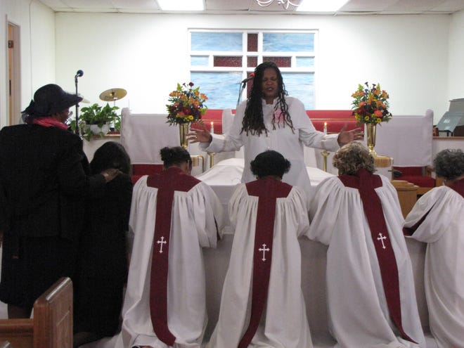 The Rev. Jacqueline L. Dupree, pastor of Mount Olive AME Church, leads members of the choir and the pulpit in prayer Sunday morning during worship service. [Photos by Aida Mallard/Special to the Guardian]