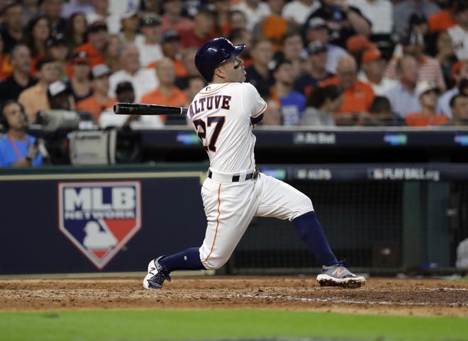 Houston's Jose Altuve follows through on his home run in the seventh inning. Altuve hit three homers in the Astros' 8-2 victory over the Boston Red Sox in Game 1 of the American League Division Series. [David J. Phillip/The Associated Press]
