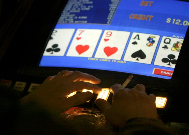 FILE - In this Feb. 17, 2005 file photo, an unidentified man plays video poker at the Carson Station in Carson City, Nev. Authorities trying to piece together the final days before Stephen Paddock unleashed his arsenal of powerful firearms on a crowd of country music fans Sunday, Oct. 1, 2017, have at least one potential trove of information: his gambling habits. Nevada gambling regulators say they're sorting through documents for clues about him and his girlfriend, Marilou Danley. (AP Photo/Cathleen Allison, File)