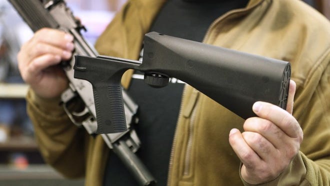 A bump stock device (right), which fits on a semi-automatic rifle to increase the firing speed, making it similar to a fully automatic rifle, is shown next to a AK-47 semi-automatic rifle (left) at a gun store on Thursday in Salt Lake City. Members of Congress are talking about banning this device after it was reported to have been used in the Las Vegas shooting Sunday. (Photo by George Frey/Getty Images)