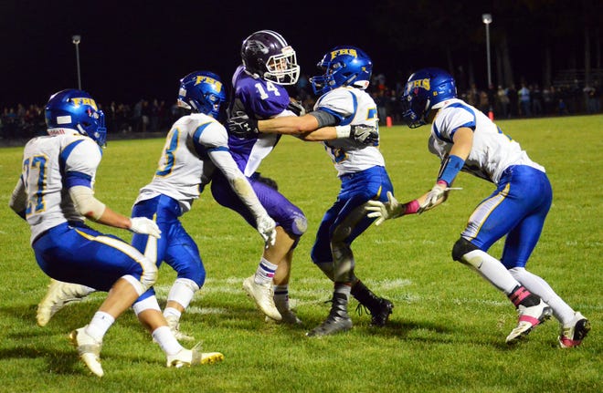 Marshwood High Schoolís Joe Taran (14) battles a swarm of Falmouth defenders for extra yardage during Friday nightís Class B South game in South Berwick, Maine. [Ryan OíLeary/Seacoastonline]