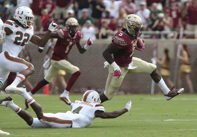 Florida State's Jacques Patrick eludes Miami's Jaquan Johnson to gain yardage in the first quarter of an NCAA college football game, Saturday in Tallahassee. [STEVE CANNON / ASSOCIATED PRESS]