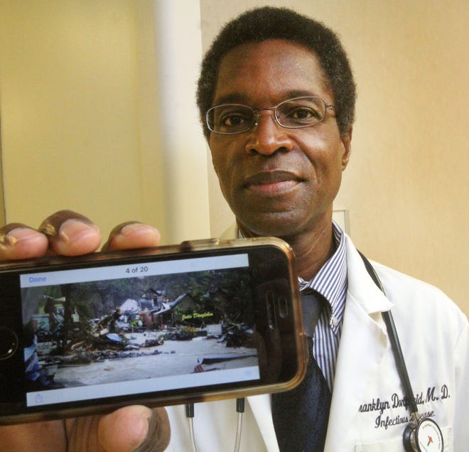 Dr. Franklyn Dontfraid , an infectious disease specialist at Halifax Health Medical Center, and a native of Dominica, shows a photograph on his cell phone of the destruction on the Caribbean island. Dontfraid joined a group of medical professionals last week going to the island as part of a relief effort.  [News-Journal/David Tucker]