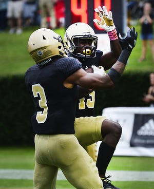 Wofford's George Gbesee (15) celebrates with teammate JoJo Tillery after picking off a pass in the end zone during overtime to seal the Terriers' 35-28 victory over Western Carolina Satuday afternoon at Gibbs Stadium. [ALEX HICKS JR/Spartanburg Herald-Journal]