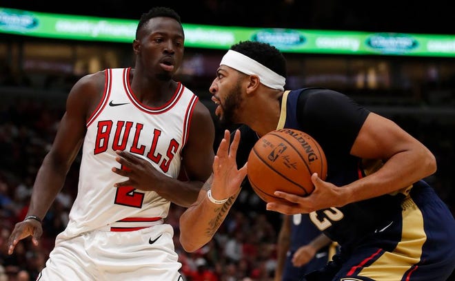 New Orleans Pelicans' Anthony Davis (right) is guarded by Chicago Bulls' Jerian Grant during the first half of Sunday's preseason game in [Jim Young/The Associated Press]