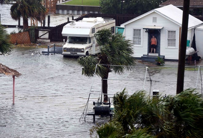 A woman looks out from her room at flooding on Sunday, Oct. 8, 2017, in Fort Walton Beach, Fla., at the Playground Motel which is situated along the Santa Rosa Sound. (Nick Tomecek/Northwest Florida Daily News via AP)