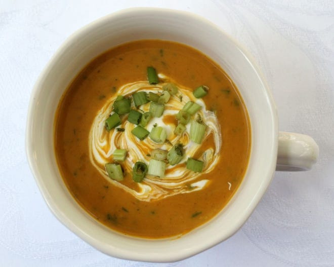 This is a spicy soup, but the sour cream with lime zest cools it down. [PHOTO BY LAURIE HIGGINS]