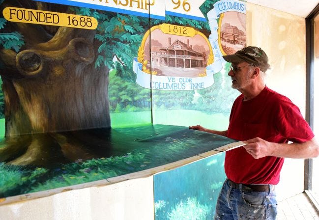Peter J. Bieling, 85, of Florence, removes a mural he painted years ago from the old municipal building in Mansfield on Monday, Oct. 9, 2017. The mural will be moved to the new township complex on Route 206.