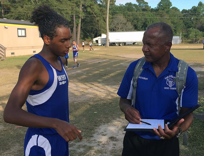 Westover senior Delsin Burkhart discusses his cross country performance with coach Eli Ballard. Burkhart, a senior, finished first in the tri-meet last week between Westover, Cape Fear and South View. [Patrick Obley/The Fayetteville Observer]