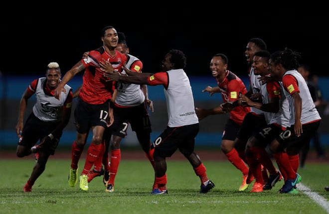 Trinidad and Tobago's Alvin Jones (17) celebrates with his teammates after scoring against U.S. during a World Cup qualifying soccer match in Couva, Trinidad, Tuesday, Oct. 10, 2017. (AP Photo/Rebecca Blackwell)