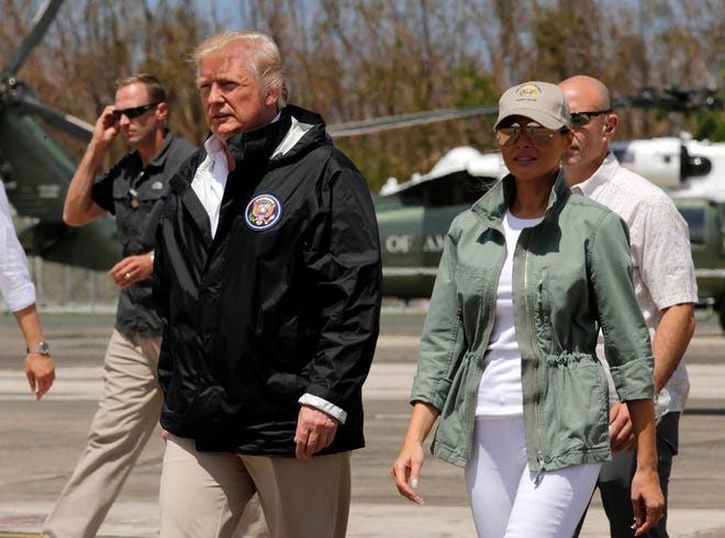 In this Oct. 3, 2017, photo, President Donald Trump and first lady Melania Trump walk after arrival at the Luis Muñiz Air National Guard Base in San Juan, Puerto Rico.