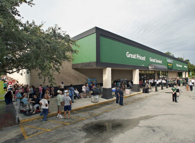 The line of customers wraps around the building at the opening of Harveys Supermarket in Winter Haven in August. Southeastern Grocers has announced that two Lakeland Winn-Dixies -- one on Ariana Street and another on U.S. 92 -- will convert to Harveys in November. [ PIERRE DUCHARME/THE LEDGER ]