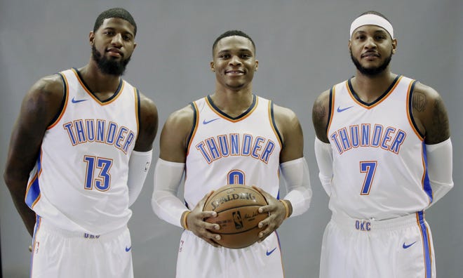 FILE - In this Sept. 25, 2017, file photo, Oklahoma City Thunder's Paul George (13), Russell Westbrook, center, and Carmelo Anthony (7) pose for a photo during an NBA basketball media day in Oklahoma City. Westbrook is a two-time scoring champion, two-time All-Star MVP and the reigning league MVP. Anthony is a 10-time All-Star and three-time Olympic gold medalist. George is a four-time All-Star, former Most Improved Player and an Olympic gold medalist. None of the new Oklahoma City Thunder teammates have an NBA title. (AP Photo/Sue Ogrocki, File)