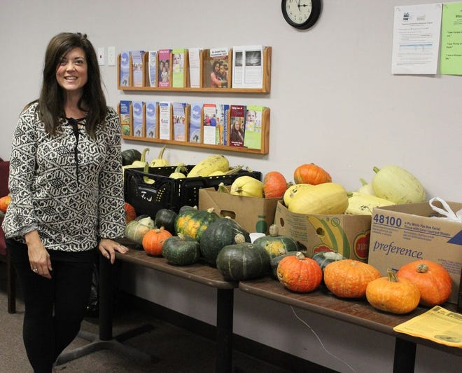 Director of the Hope Center, Katie Fitch stands in front of two of the tables loaded with fresh garden produce available at the Hope Center.