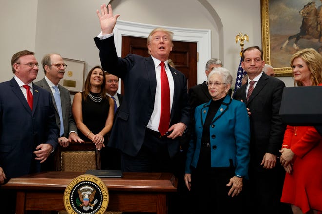 President Donald Trump waves after signing an executive order on health care in the Roosevelt Room of the White House, Thursday, Oct. 12, 2017, in Washington. (AP Photo/Evan Vucci)