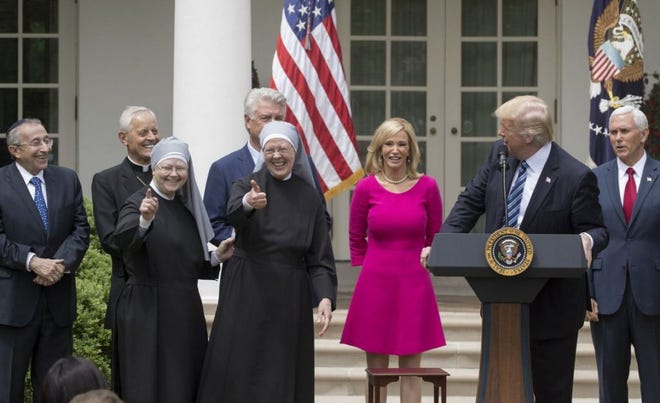 Nuns with the Little Sisters of the Poor give a thumbs up at a National Day of Prayer event with President Donald Trump and other religious leaders in the Rose Garden at the White House, in Washington. Trump signed an executive order aimed at easing restrictions on political activity by tax-exempt churches and charities.