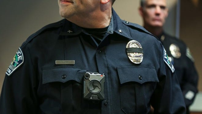 Austin police intelligence and technology commander Brent Dupr, demonstrates body cameras at the Austin Police Department’s East Substation on Friday. QILING WANG / AMERICAN-STATESMAN
