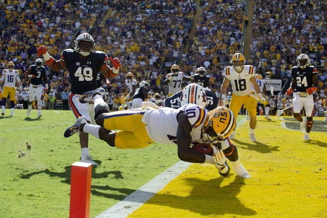 LSU wide receiver Stephen Sullivan (10) dives into the end zone as he takes a hit from Auburn linebacker Deshaun Davis (57) in LSU's 27-23 victory on Saturday. [Albert Cesare/The Montgomery Advertiser, AP]