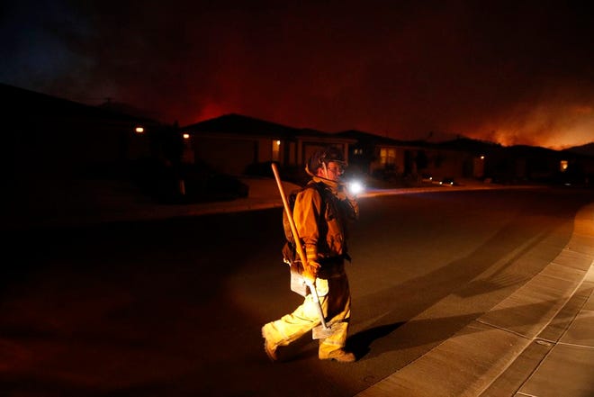 A firefighter looks for flammable items in an evacuated residential area as wildfires continue to burn Saturday, Oct. 14, 2017, in Santa Rosa, Calif. Fire officials have ordered mandatory evacuations. (AP Photo/Jae C. Hong)