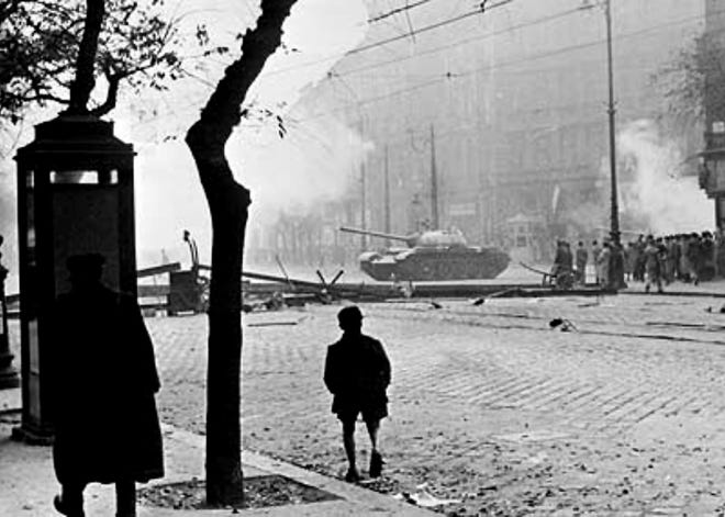 A Soviet tank attempts to clear a road barricade in Budapest, Hungary, in October 1956. [Photo via Wikipedia]