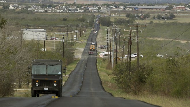 This rippled and flood-prone section of Elroy Road near Circuit of the Americas’ north entrance, pictured in 2012, will be widened and raised out of the flood plain by Travis County using borrowed money. RALPH BARRERA/AMERICAN-STATESMAN