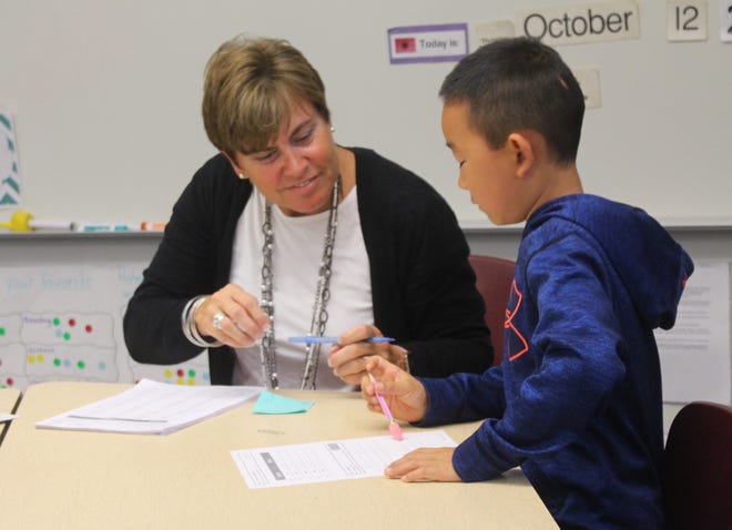 Peggy Housenga looks over one of her third-graders work at Bentheim Elementary. Housenga is in her 33rd year of teaching with Hamilton Community Schools. [Erin Dietzer/Sentinel staff]