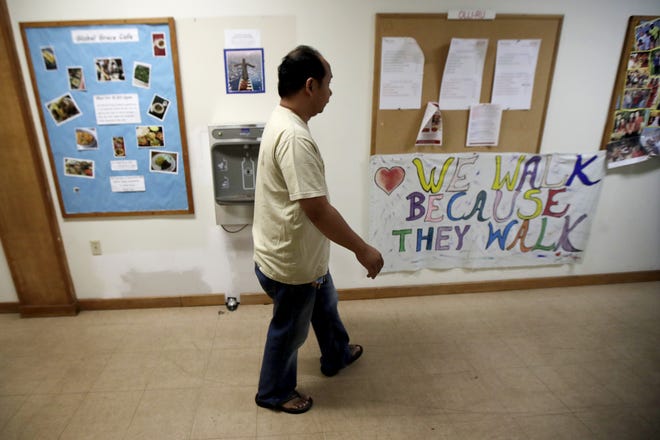 Arthur Jemmy walks through a hallway at The Reformed Church of Highland Park, where he and his wife are taking sanctuary to avoid deportation, Thursday, Oct. 12, 2017, in Highland Park, N.J. The church, who is led by pastor Seth Kaper-Dale, a Green Party candidate in the New Jersey gubernatorial election, has a history of hosting immigrants in danger of deportation. The candidate's platform includes declaring New Jersey a sanctuary state. (AP Photo/Julio Cortez)
