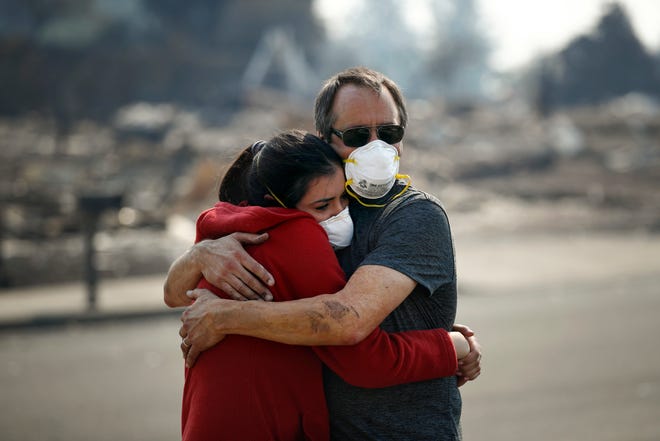 Howard Lasker, right, comforts his daughter, Gabrielle, who is visiting their home for the first time since a wildfire swept through it Sunday, Oct. 15, 2017, in Santa Rosa, Calif. With the winds dying down, fire officials said Sunday they have apparently "turned a corner" against the wildfires that have devastated California wine country and other parts of the state over the past week, and thousands of people got the all-clear to return home. (AP Photo/Jae C. Hong)