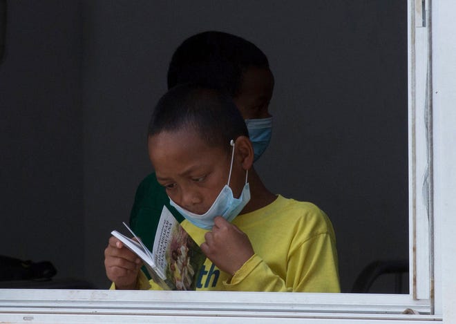 In this photo taken Tuesday Oct. 10, 2017, a girl wears a face mask inside a hospital in the capital Antananarivo, Madagascar. A plague outbreak has brought some panic to the city dwellers with schools closed and public gatherings banned as the death toll still mounts in the Indian Ocean island nation. (AP Photo/Alexander Joe)