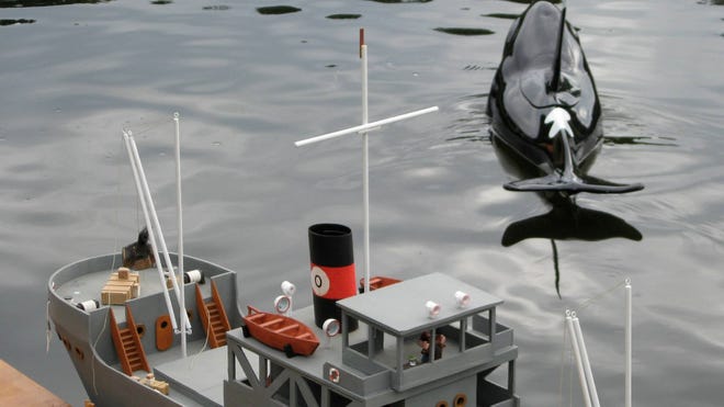 The North Florida Operating and Radio Controlled Association of Shipwrights’ model killer whale cruises away from a miniature dock past the S.S. Olive, with a petite Popeye at the helm, at a recent regatta at Losco Regional Park. (Dan Scanlan/Florida Times-Union)