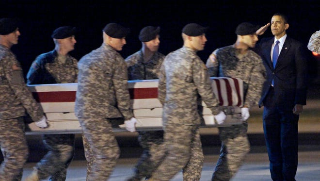 In this Oct. 29, 2009, photo President Barack Obama, right, salutes as an Army carry team carries the transfer case containing the remains of Sgt. Dale R. Griffin of Terre Haute, Ind., during a casualty return at Dover Air Force Base, Del. (Associated Press, file)