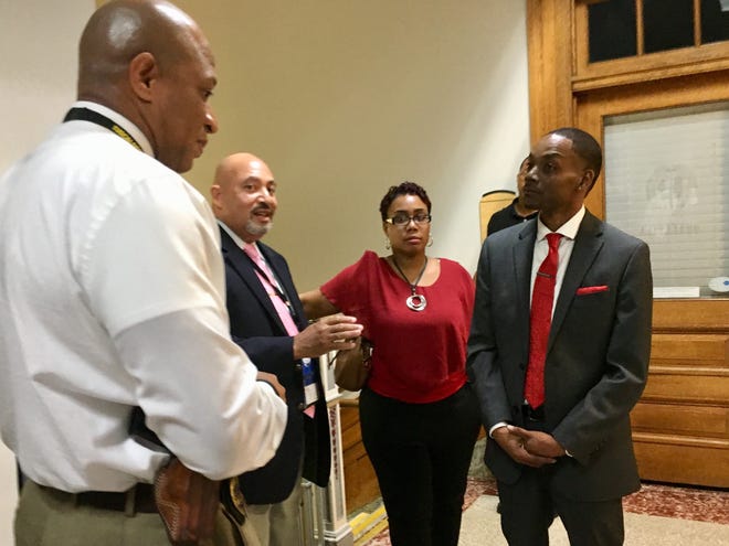 Derrick Crummie, far right, speaks with city officials at the Tuscaloosa City Council meeting last week. [Staff file photo / Jason Morton]