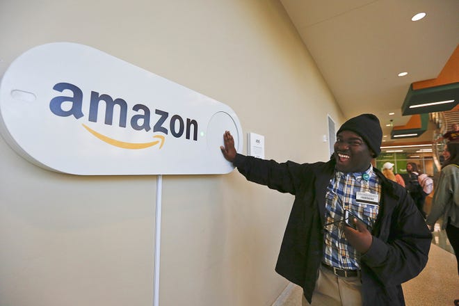 In this Monday, Oct. 16, 2017, photo, Zavian Tate, a student at the University of Alabama at Birmingham, pushes a large Amazon Dash button, in Birmingham, Ala. The large Dash buttons are part of the city's campaign to lure Amazon's second headquarters to Birmingham. (AP Photo/Brynn Anderson)