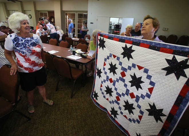 Judy Sweet shows a quilt she made to raise money for the building of Whisperwood Veterans Plaza in DeLand. She shared the item with other residents of the DeLand manufactured home park at a meeting Saturday, Oct. 14, 2017. [News-Journal/Nigel Cook]