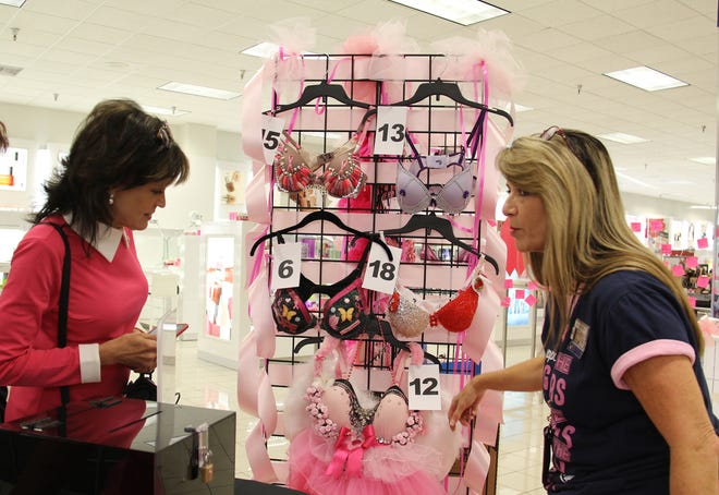 Naval Air Station Jacksonville Navy Exchange (NEX) General Manager Marsha Brooks (right) and First Coast News Anchor Jeannie Blaylock check out some of the decorated bras submitted for the Battle of the Bras competition sponsored by the NEX.